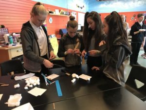 Students making paper airplanes using math and engineering tools.