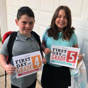 students holding up first day of school signs